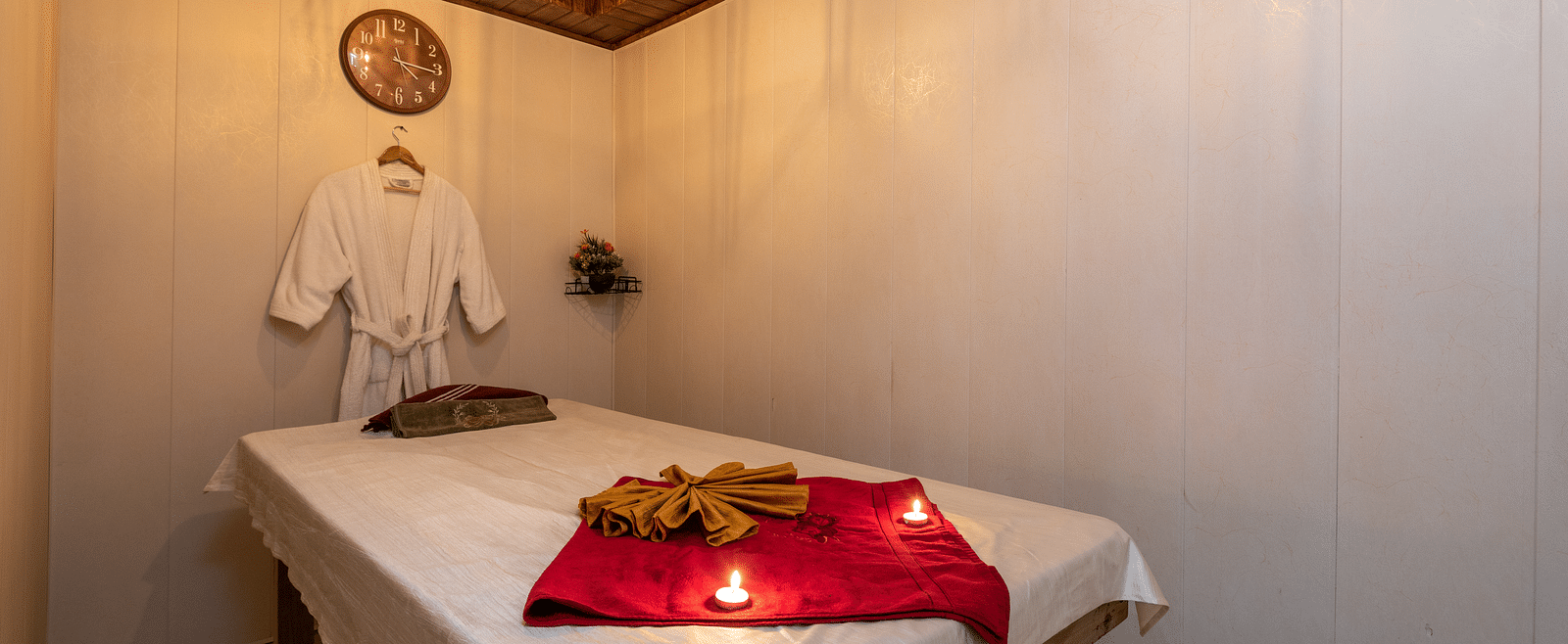 View of the massaging table with a bathrobe hung near the pillow at DLS Highland Resort and Spa, Mussoorie.